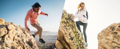 Man jumping between rocks. Women climbing rocks. 